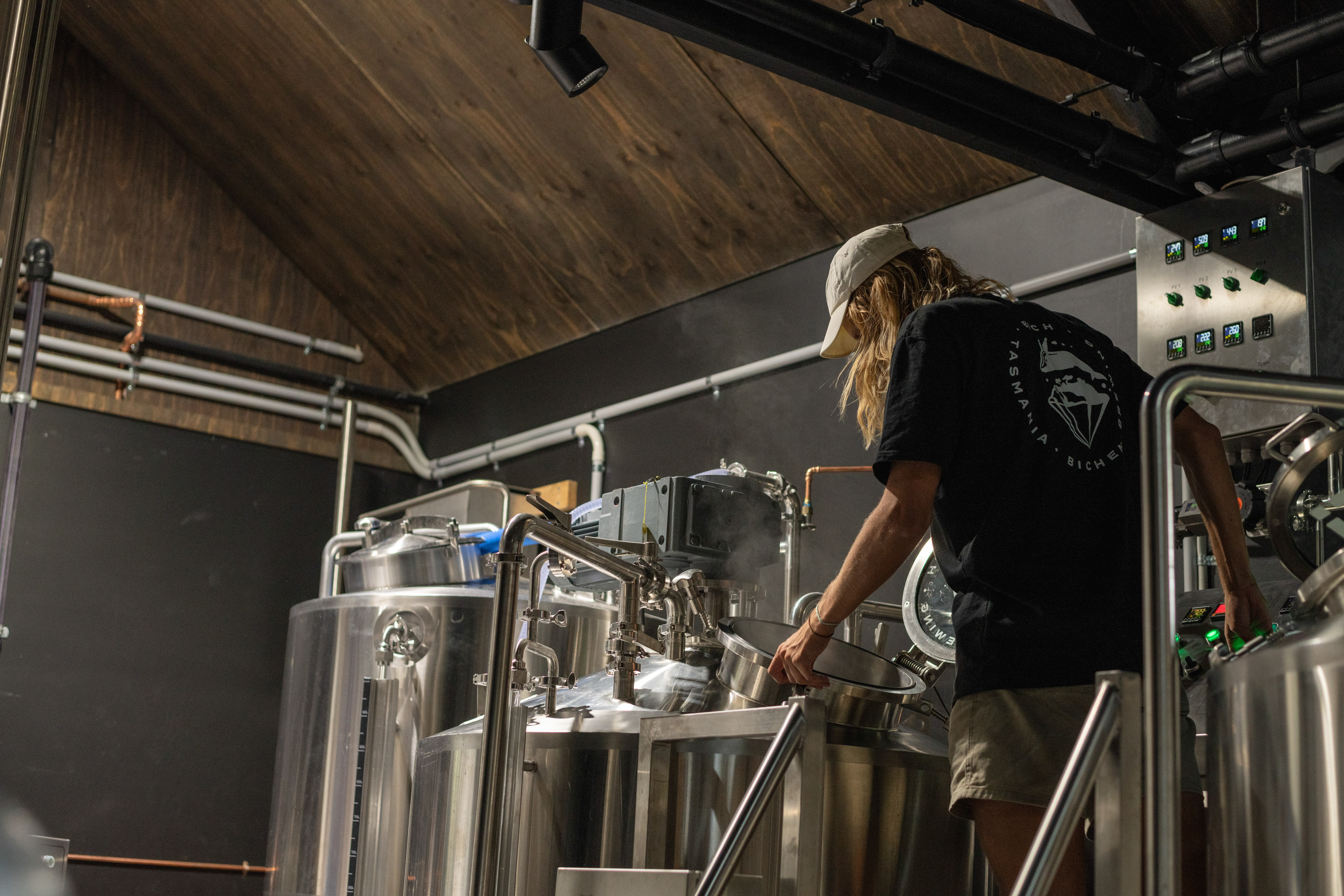 An image of a person adjusting the brewing equipment.